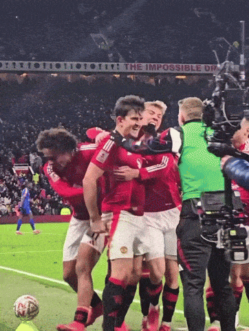 a group of soccer players are hugging each other in front of a sign that says the impossible dream