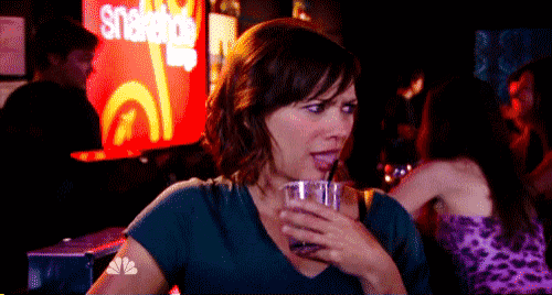 a woman drinking from a straw in front of a sign that says snapple