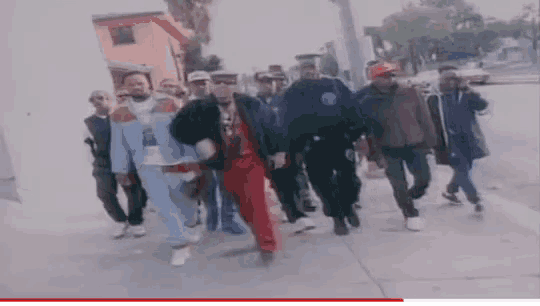 a group of men are walking down a sidewalk in a blurry picture