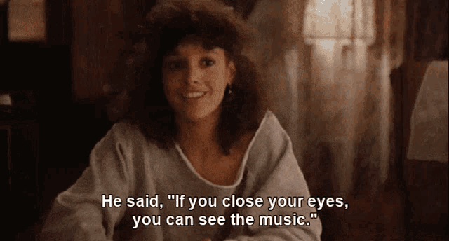 a woman sitting at a table with the words he said " if you close your eyes you can see the music " below her