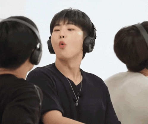 a young man wearing headphones is making a face