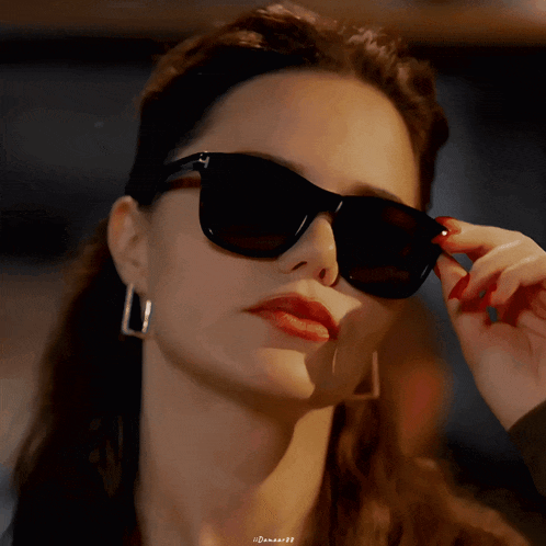 a close up of a woman wearing sunglasses with a caption that says ' danae99 '
