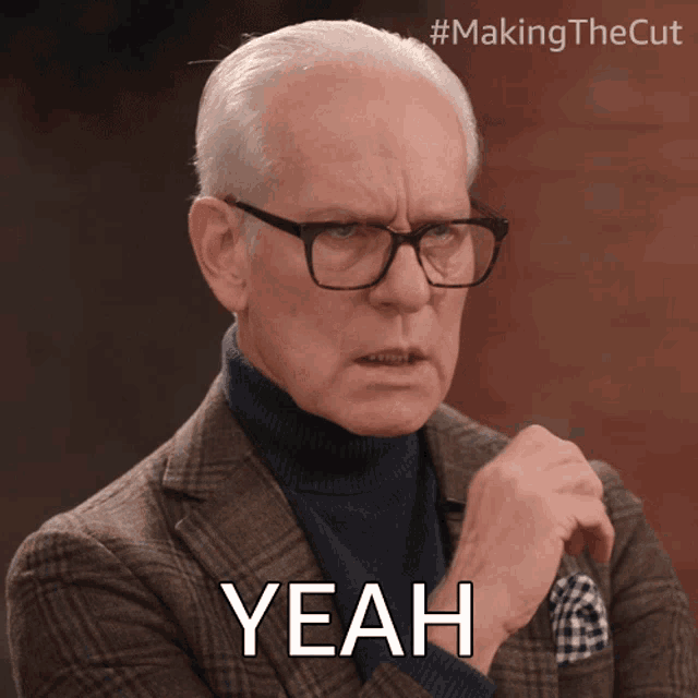 a man wearing glasses and a plaid suit says yeah