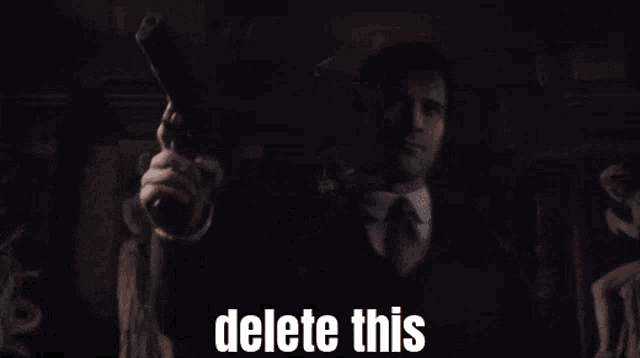 a man in a suit and tie is pointing a gun with the words delete this written below him