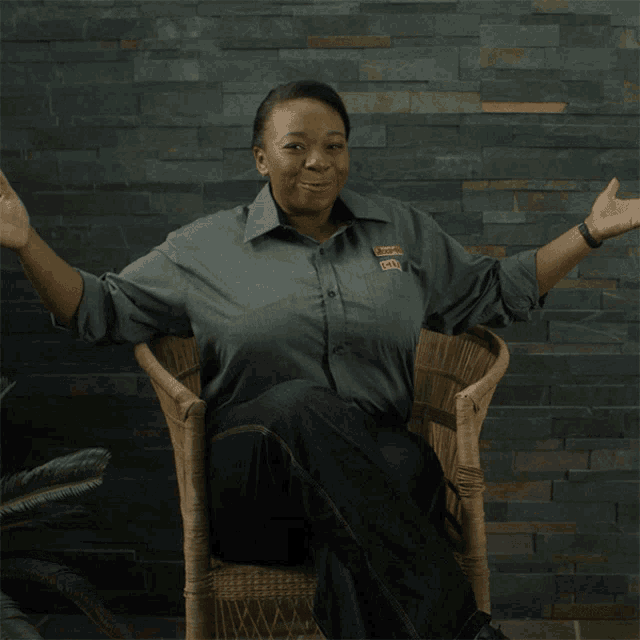 a woman is sitting in a chair with her arms outstretched wearing a shirt that says ' cafe ' on the front