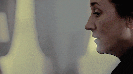 a close up of a woman 's face with a yellow light behind her