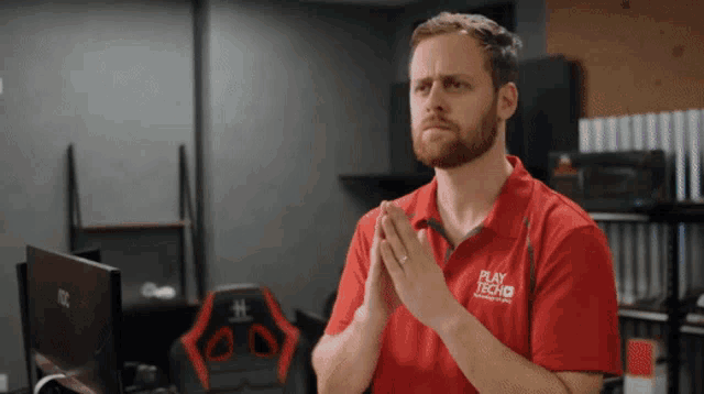 a man wearing a red shirt with play tech on it