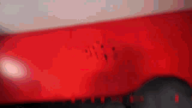 a close up of a red object with a few spots on it