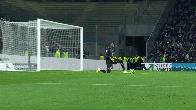 a soccer player kneels on the field in front of a museum des verts sign