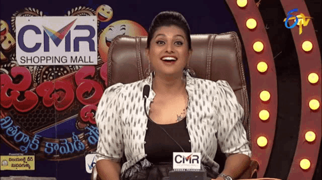 a woman sitting in front of a cmr shopping mall logo