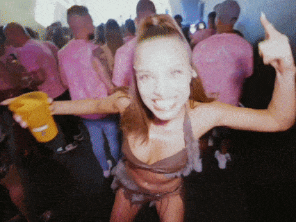 a woman in a bikini holds a yellow cup in her hand