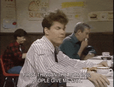 a man sits at a table with a cup of coffee and says first thing in the morning people give me shit ..