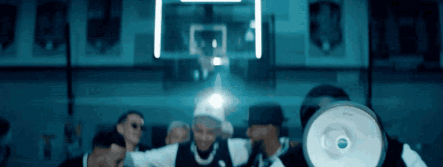 a group of men are standing in front of a basketball hoop and a megaphone