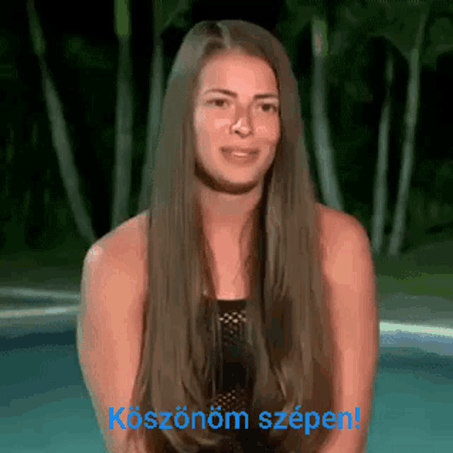 a woman with long hair is sitting in front of a pool with the words koszonom szpen written on the bottom