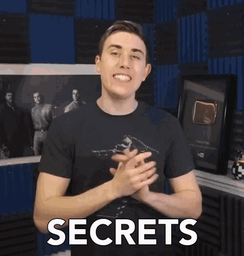 a man wearing a black shirt with the word secrets on the front