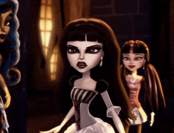 two monster high dolls are standing next to one another