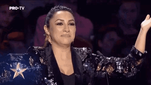 a woman in a sequined jacket stands in front of a pro tv star
