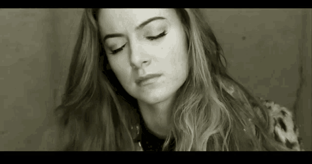 a black and white photo of a young woman with her eyes closed .