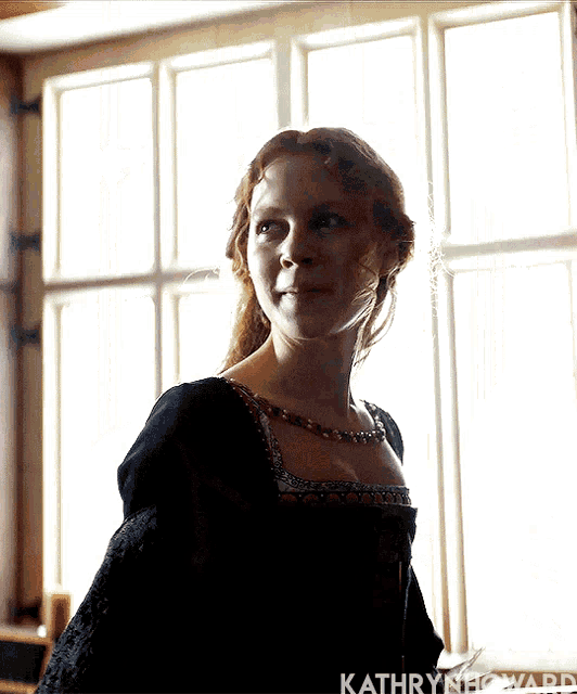 a woman in a black dress is standing in front of a window with kathryn howard written on the bottom