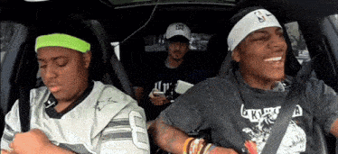 three people in a car with one wearing a headband with the letter s on it