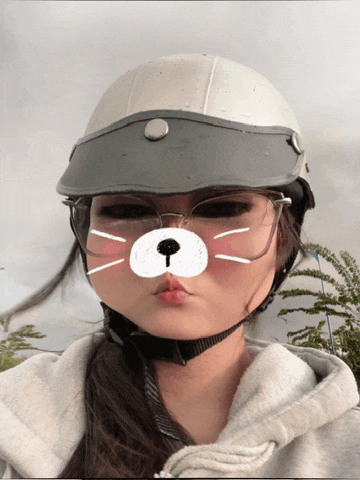 a girl wearing a helmet and glasses looks like a cat