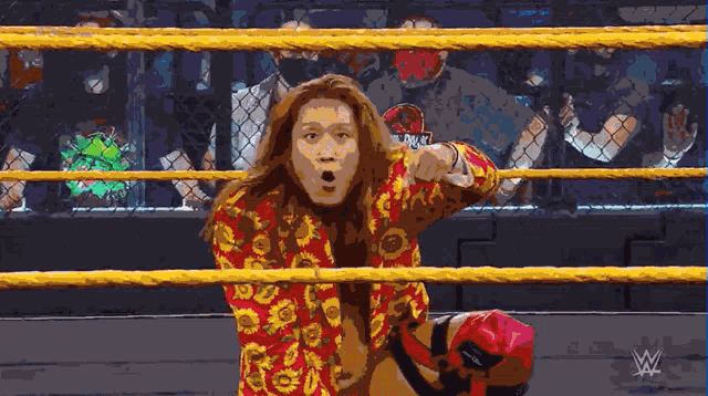 a man in a wrestling ring with a w logo in the corner