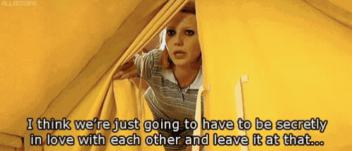 a woman is peeking out from behind a yellow curtain and says i think we 're just going