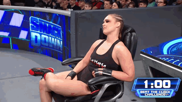 a woman sits in a chair in front of a smack down banner