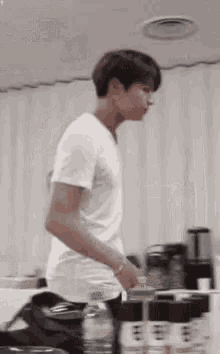 a young man in a white shirt is standing in a room .