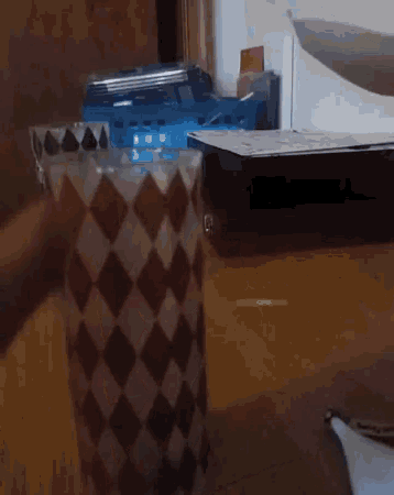 a glass with a checkered pattern sits on a wooden table