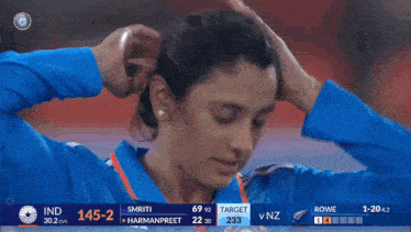 a woman 's face is shown on a television screen during a cricket match between india and nz
