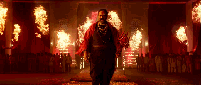 a man in a red robe is holding a sword in front of a crowd of people