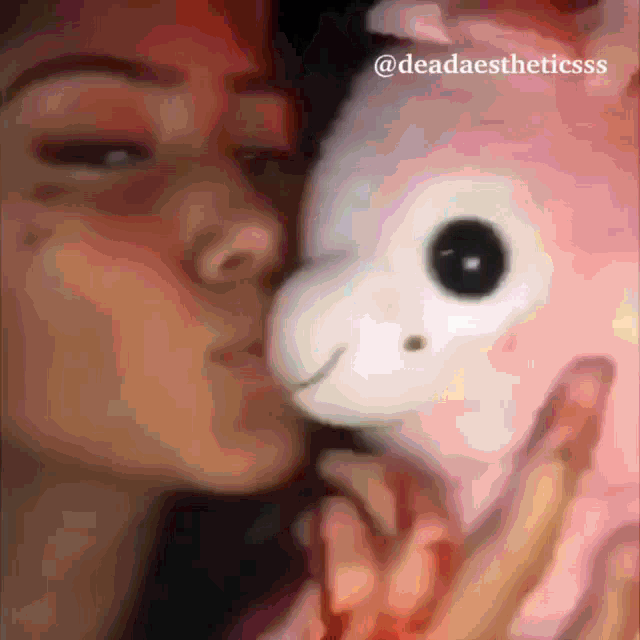 a blurred image of a woman kissing a stuffed animal with the caption deadaestheticss