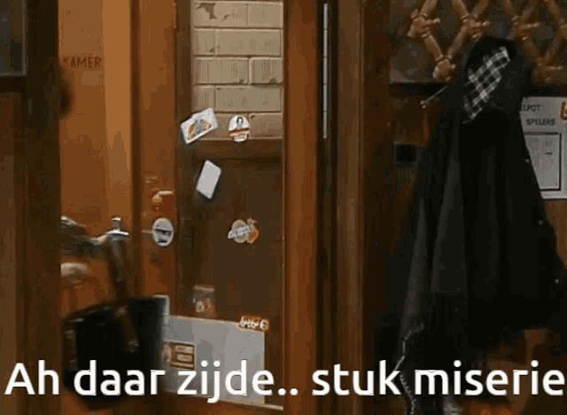 a door with stickers on it and the words ah daar zijde stuk miserie below it