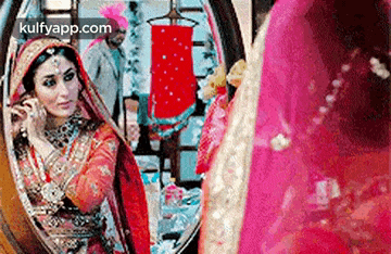 a bride is looking at herself in the mirror .