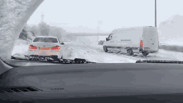 a white car with a license plate that says ' nl ' on it is driving through the snow