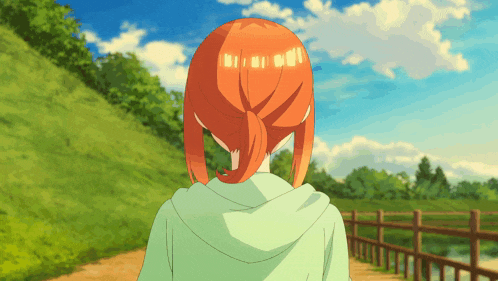 a girl with red hair is walking down a path in a park