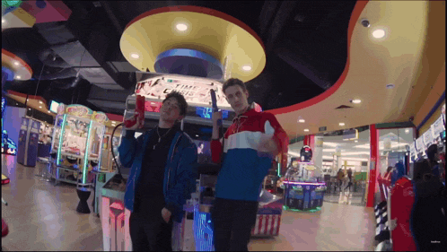 two men are standing in an arcade with a sign that says " chris "