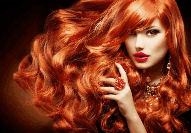 a woman with long red hair wearing a ring