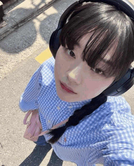 a woman wearing headphones and a plaid shirt