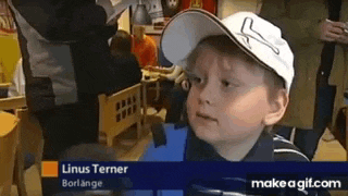 a young boy wearing a baseball cap is sitting at a table in a restaurant .