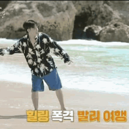 a man in a hawaiian shirt is standing on the beach .