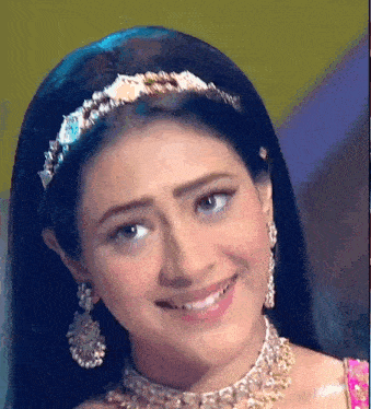 a close up of a woman wearing a headband and necklace smiling .