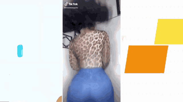 a woman in a leopard print top and blue jeans is dancing on a tiktok video .