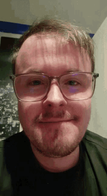 a man with glasses and a beard is making a face