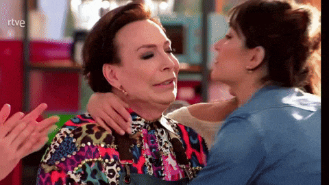 a woman hugging another woman with rtve written on the bottom