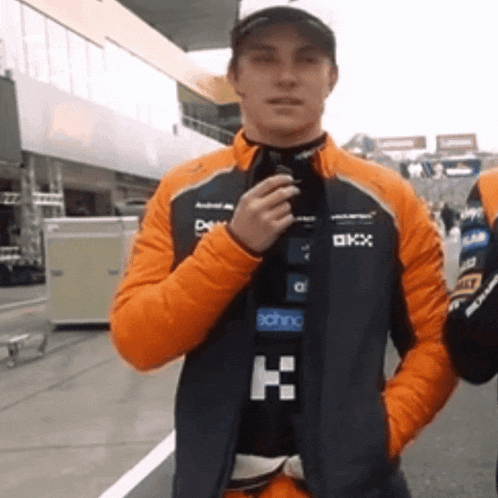 a man wearing an orange jacket with the letter k on it