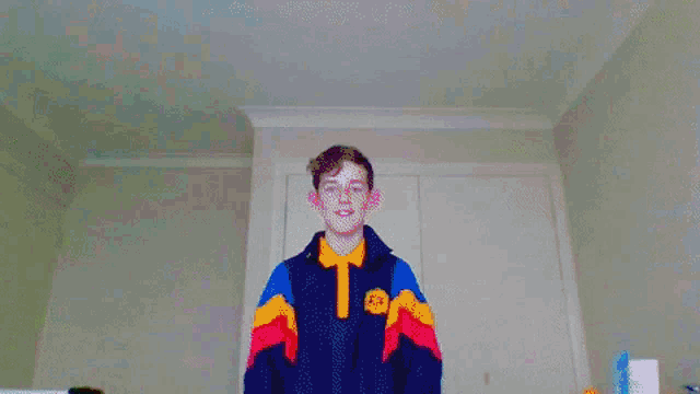 a person in a rainbow colored jacket is dancing in a room