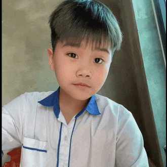 a young boy wearing a white shirt with a blue collar looks at the camera