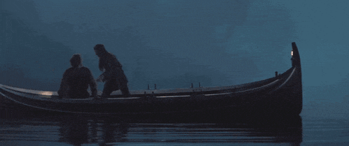 a couple standing in a boat in the water
